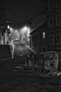 Illuminated street amidst buildings in city at night