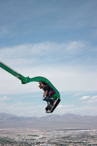 Man jumping on mountain against sky