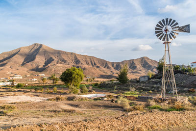 Traditional windmill on mountain against sky