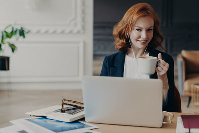 Portrait of woman with coffee cup on table