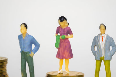 People standing by stuffed toy against white background