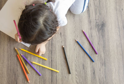 High angle view of girl drawing on table