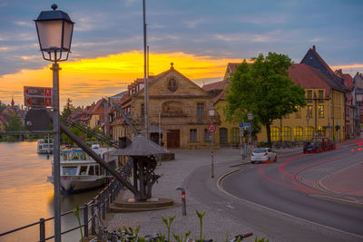 People walking on city street at sunset