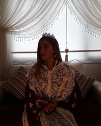 Young woman looking away while sitting at home