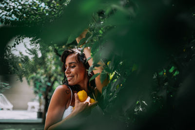 Smiling young woman looking at plants