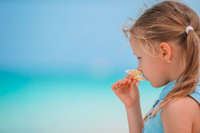 Portrait of girl against blue sky