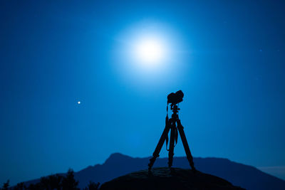 Low angle view of camera against blue sky