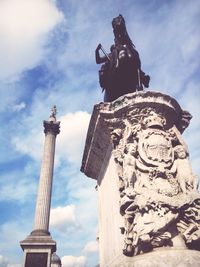 Low angle view of eiffel tower against cloudy sky