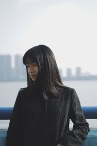 Young woman standing against clear sky