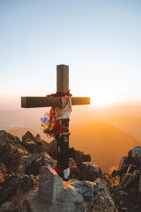 Rear view of man standing on rock against clear sky