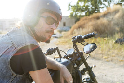 Smiling man wearing sunglasses sitting on bike