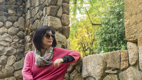 Portrait of woman standing against wall