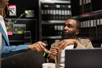 Side view of young man using mobile phone in office