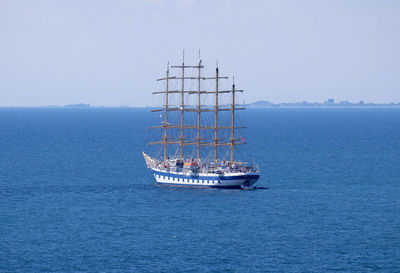 Sailboat sailing on sea against clear sky