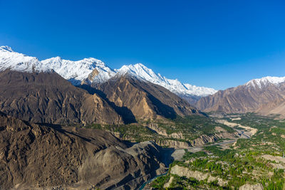 Scenic view of snowcapped mountains against clear blue sky