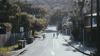 PEOPLE WALKING ON ROAD AMIDST TREES