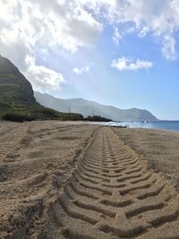 Scenic view of beach against cloudy sky