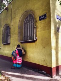 Rear view of woman standing in front of building