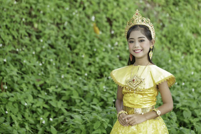 Smiling girl standing against plants