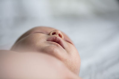 Close-up of baby lying on bed