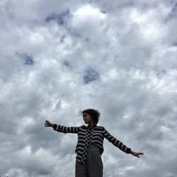 Low angle view of woman standing against sky