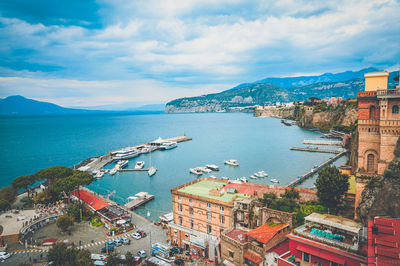 High angle view of townscape by sea against sky