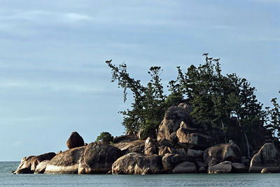 Rocks by sea against sky