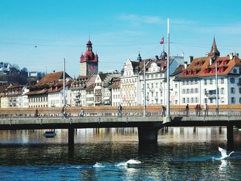 Bridge over river in city against sky