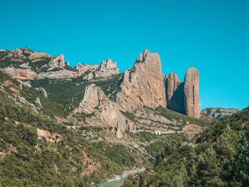 Low angle view of mountains against clear blue sky