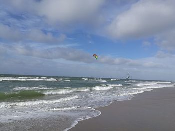 Scenic view of beach against cloudy sky