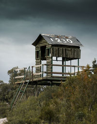 Low angle view of old house on field against sky