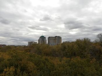 Buildings in city against cloudy sky