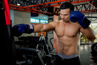 Shirtless muscular man exercising at gym