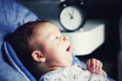 Close-up portrait of cute baby lying on bed