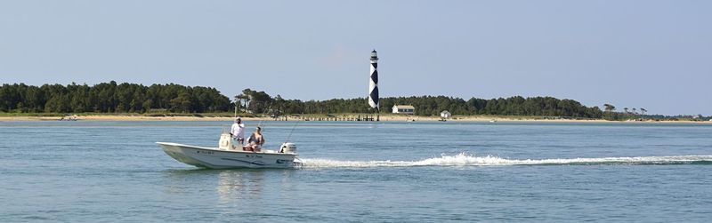 Boat sailing in sea against clear sky