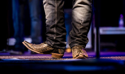 Low section of man wearing shoes on stage during concert