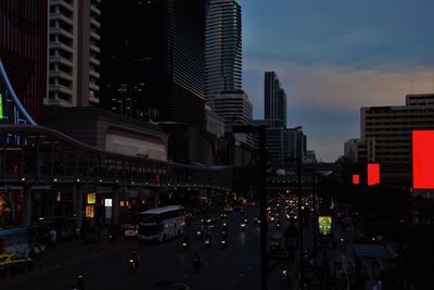 Traffic on city street by buildings against sky