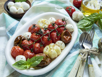 Salad. baked tomato, basil, garlic with mozzarella cheese, ceramic dishes. cooking, cooked dish