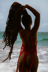 Rear view of woman standing at beach