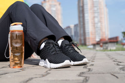 Low section of man sitting on footpath