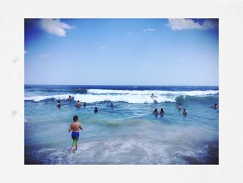 People on beach against blue sky