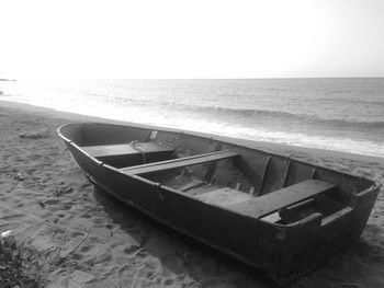 Boat moored on beach against sky