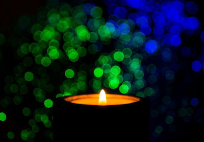Close-up of illuminated candle against black background