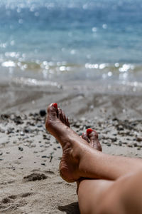 Low section of woman relaxing at beach