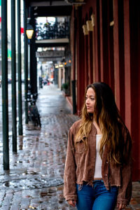 Beautiful young woman standing against building