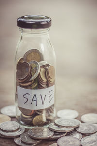 Close-up of coins in jar on table