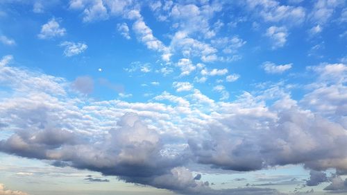 Low angle view of sunlight streaming through clouds