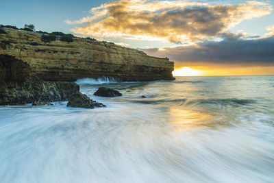 Sunrise at sandy beach with waves