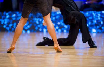 Low section of people dancing on hardwood floor