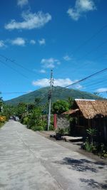 Road amidst buildings against sky